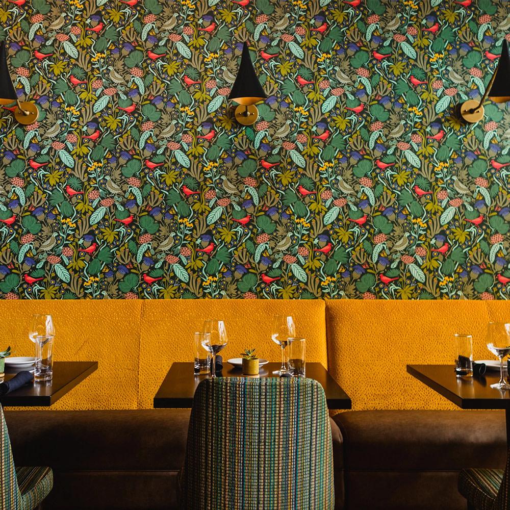 The Mayton Hotel's restaurant with floral and bird wallpaper.