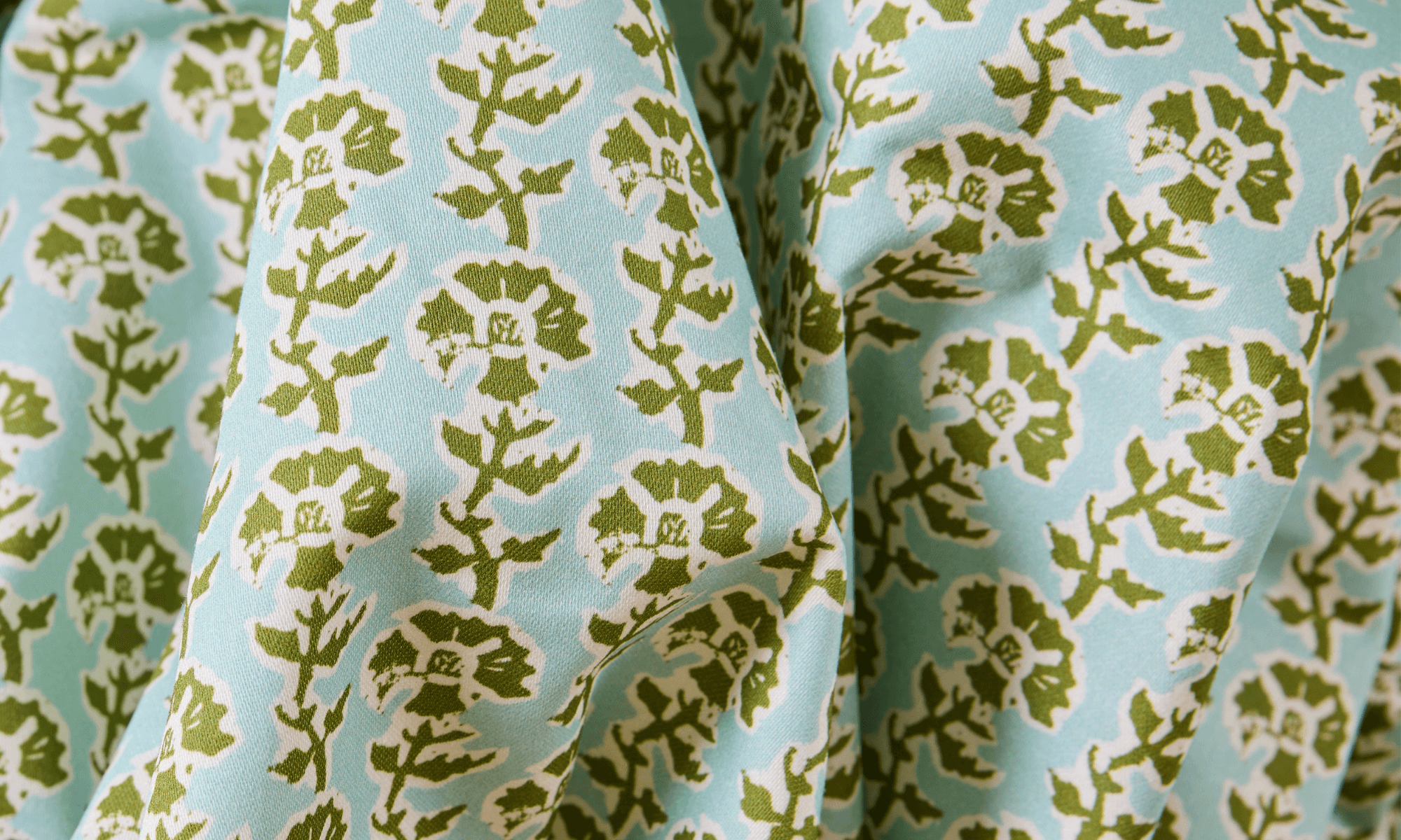 Medium weight 6.5 oz extra wide cotton sateen printed with blue and green floral design.