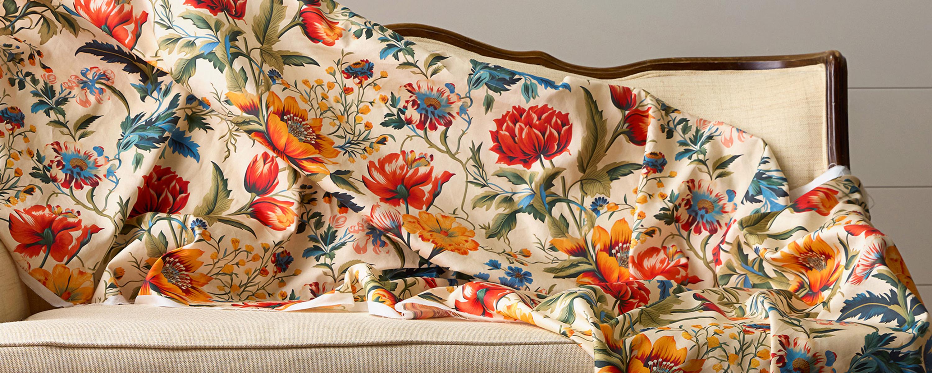 Floral wide cotton sateen 6.5oz fabric draped over a settee.