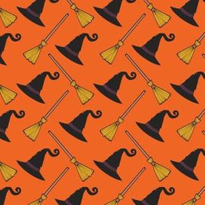 Witch hats and brooms on orange